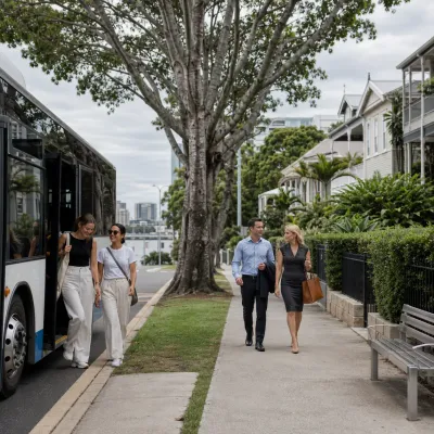 Residents using public transport and walking through a leafy Brisbane suburb with Queenslander homes, representing everyday lifestyle in one of the best Brisbane suburbs to live in for 2026.