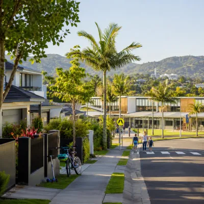 Family-friendly Gold Coast suburb with modern homes, a local school, safe pedestrian crossing and children walking to class in a leafy neighbourhood.