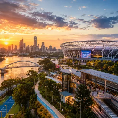 Brisbane skyline, riverfront stadium and transport infrastructure at sunset, representing property investment opportunities ahead of the Brisbane 2032 Olympics.