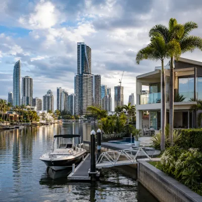 Broadbeach Waters canal home with private jetty and boat overlooking the Broadbeach skyline, representing the area’s premium waterfront lifestyle and property appeal.