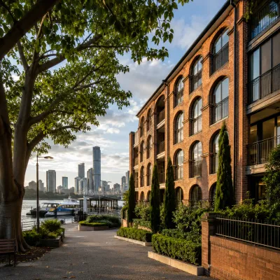 Prestigious New Farm and Teneriffe riverside setting with heritage-style brick residences, ferry access and the Brisbane skyline, representing premium inner-city property buying.