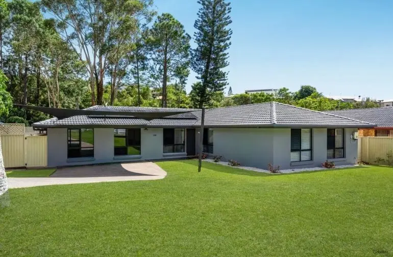 Rendered single-storey home with a wide front lawn and shade sail at 170 K P McGrath Drive, Elanora