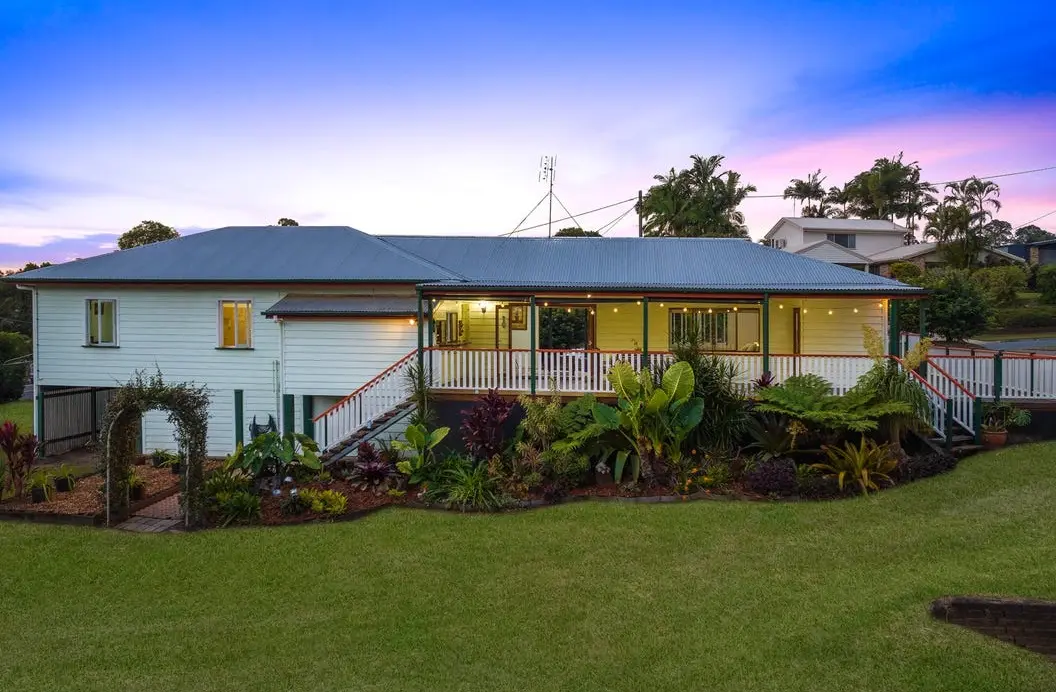 Queenslander-style home with a verandah and landscaped gardens at dusk, 2–6 Upper Wakefield Street, Woombye